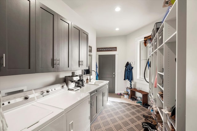 clothes washing area featuring cabinets, sink, and washer and clothes dryer