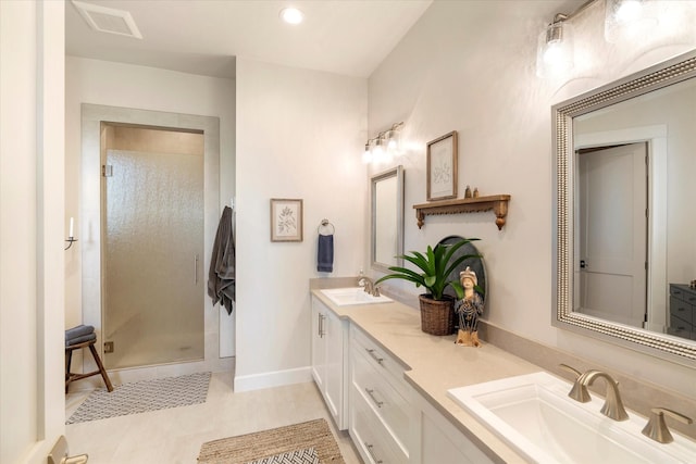 bathroom with a shower with door, vanity, and tile patterned flooring