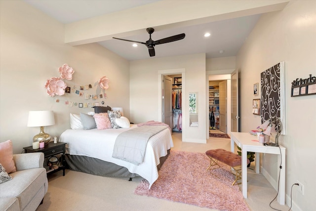 carpeted bedroom featuring ceiling fan, a walk in closet, a closet, and beamed ceiling