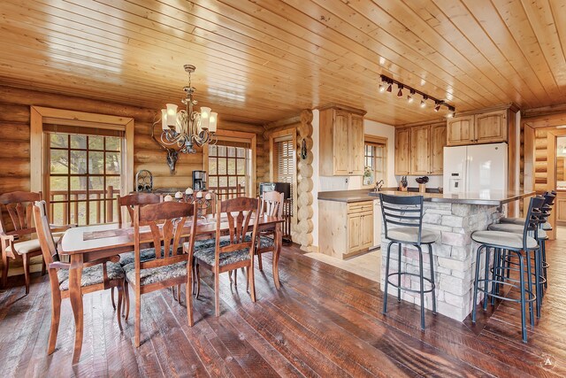 dining room featuring an inviting chandelier, track lighting, wood-type flooring, rustic walls, and wood ceiling