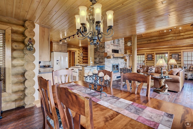 dining room with an inviting chandelier, wood-type flooring, a stone fireplace, rustic walls, and wood ceiling