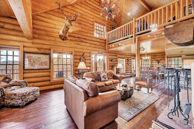 living room with a high ceiling, dark hardwood / wood-style floors, log walls, and an inviting chandelier