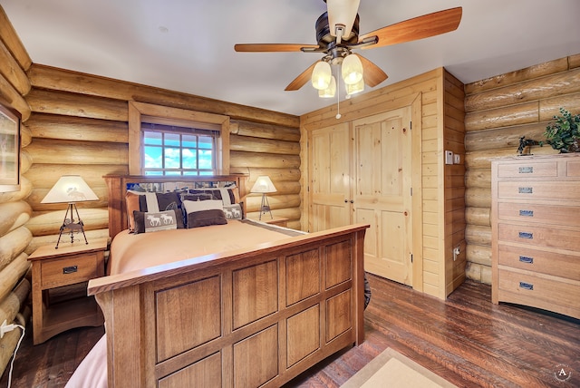 bedroom with rustic walls, ceiling fan, and dark hardwood / wood-style floors