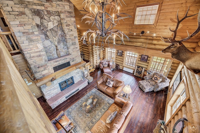 living room with high vaulted ceiling, rustic walls, and wood-type flooring