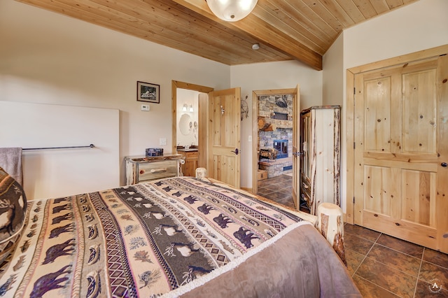 bedroom with dark tile floors, beam ceiling, and wood ceiling