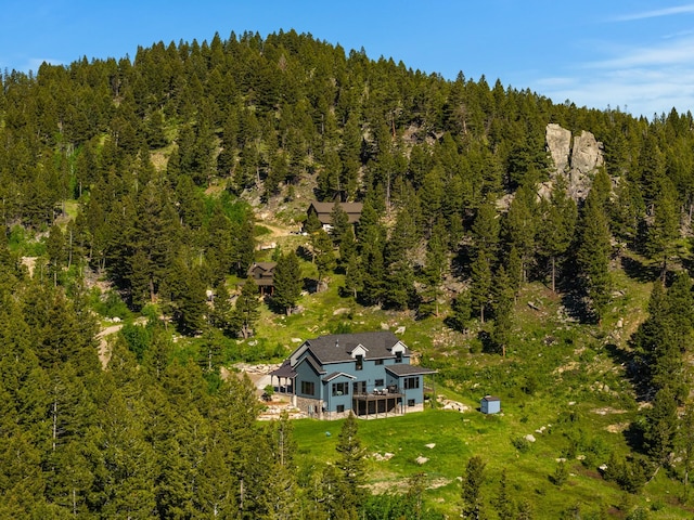 drone / aerial view with a wooded view