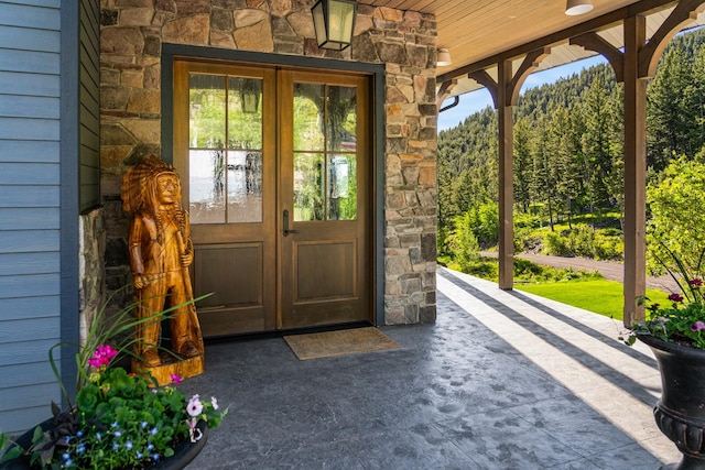 property entrance with stone siding and french doors