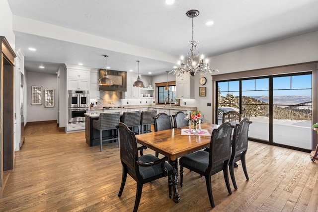 dining room featuring recessed lighting, a mountain view, light wood-style flooring, and baseboards