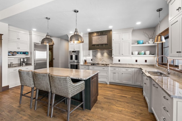 kitchen featuring stainless steel appliances, a sink, white cabinetry, a center island, and open shelves