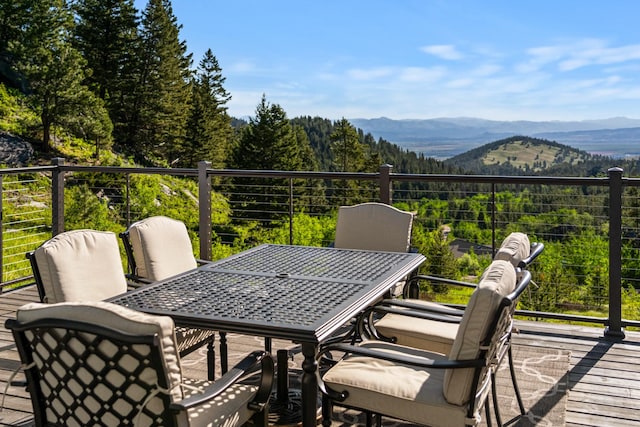 wooden terrace featuring outdoor dining area and a mountain view