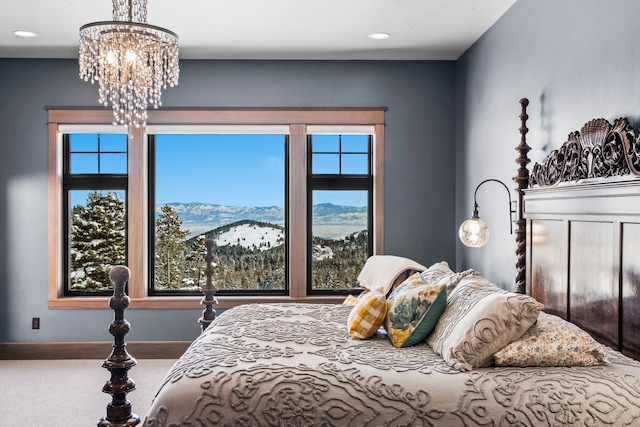 carpeted bedroom with a chandelier, a mountain view, and baseboards