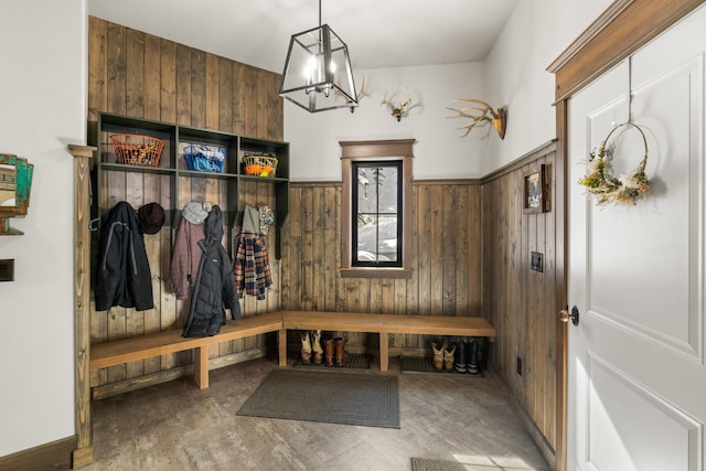 mudroom with wood walls and an inviting chandelier