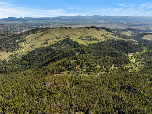 drone / aerial view with a wooded view and a mountain view