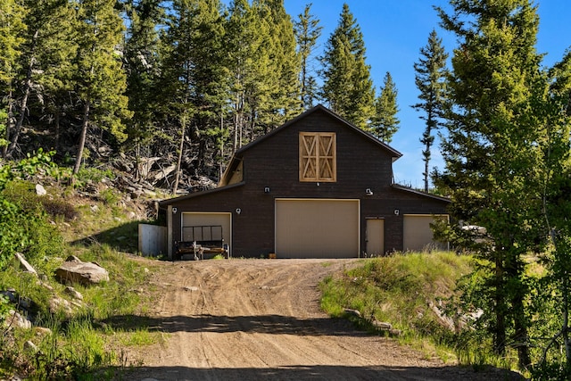 view of front of house with an outdoor structure, a detached garage, and a barn