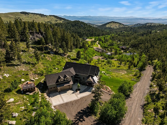 birds eye view of property with a forest view and a mountain view