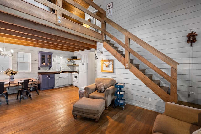 sitting room featuring a chandelier, wood finished floors, and stairs