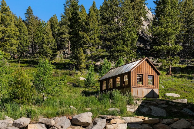 view of outbuilding with a view of trees and an outbuilding