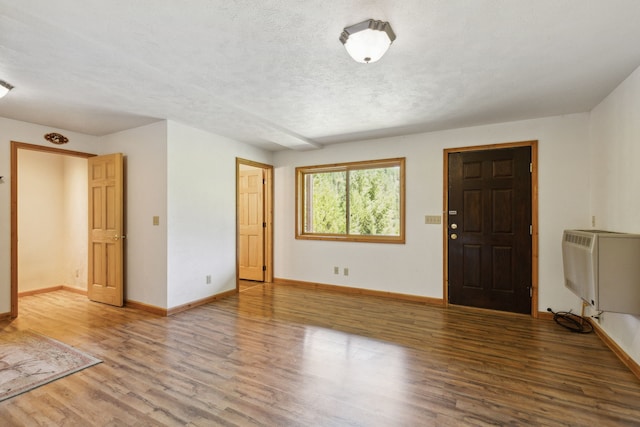 interior space with a textured ceiling and hardwood / wood-style floors