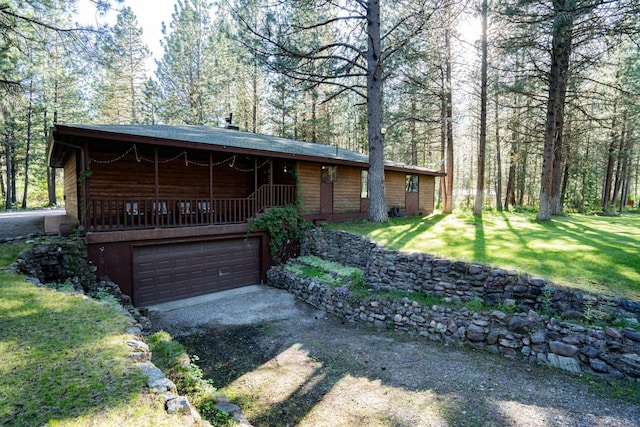 view of front of house featuring dirt driveway, a front yard, and a garage