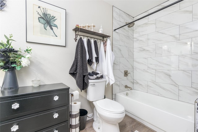 bathroom with toilet, tiled shower / bath combo, and hardwood / wood-style floors