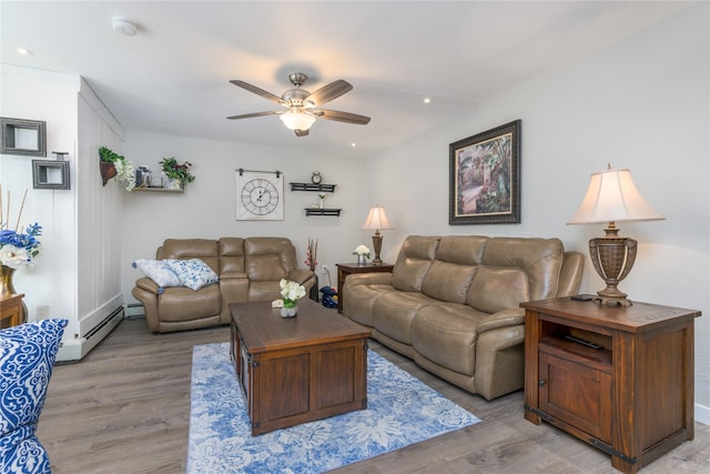 living room featuring light hardwood / wood-style floors, a baseboard heating unit, and ceiling fan