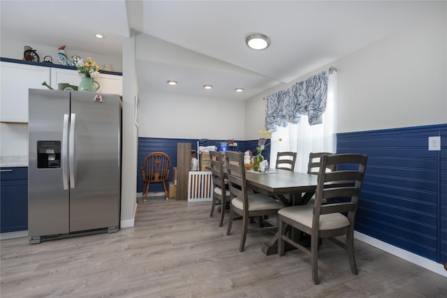 dining space featuring light hardwood / wood-style floors and vaulted ceiling