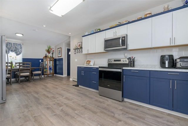 kitchen featuring light wood-type flooring, stainless steel appliances, blue cabinets, and white cabinets