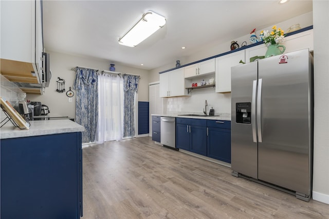 kitchen featuring sink, light wood-type flooring, stainless steel appliances, white cabinets, and blue cabinets