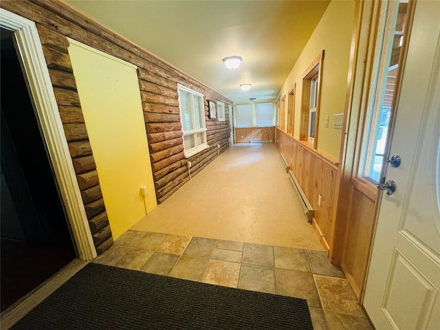 hall featuring rustic walls, wooden walls, and a baseboard radiator