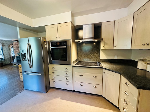 kitchen featuring light hardwood / wood-style floors, wall chimney exhaust hood, brick wall, and appliances with stainless steel finishes