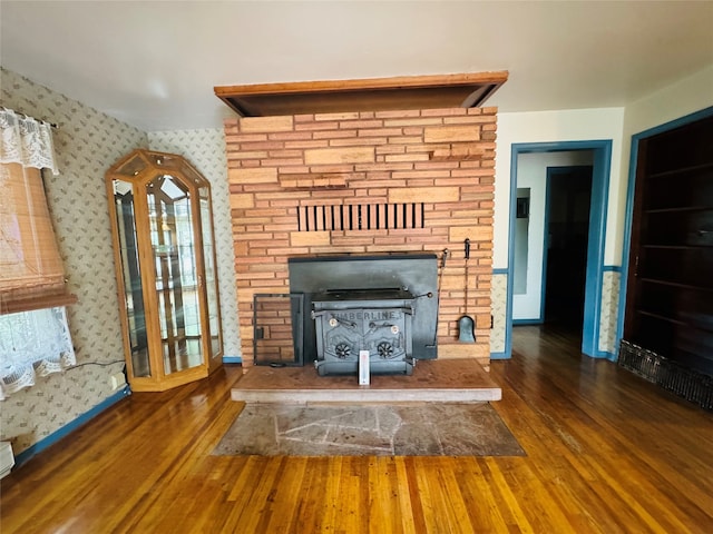 unfurnished living room featuring a wood stove and dark hardwood / wood-style flooring