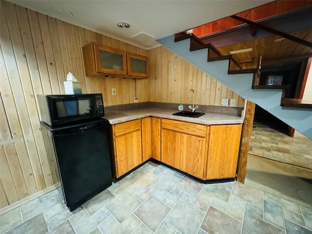 8 Cedar Gulch Ln, Thompson Falls, MT 59873 - kitchen featuring black microwave, wood walls, fridge, stone finish floors, and brown cabinetry