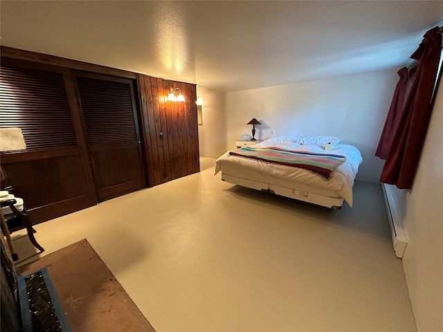 bedroom with a baseboard heating unit and concrete floors