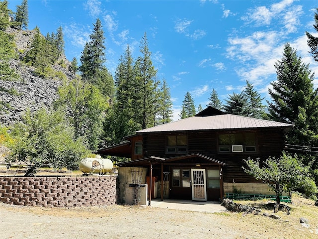 8 Cedar Gulch Ln, Thompson Falls, MT 59873 - view of front of property featuring a patio, a metal roof, and log siding