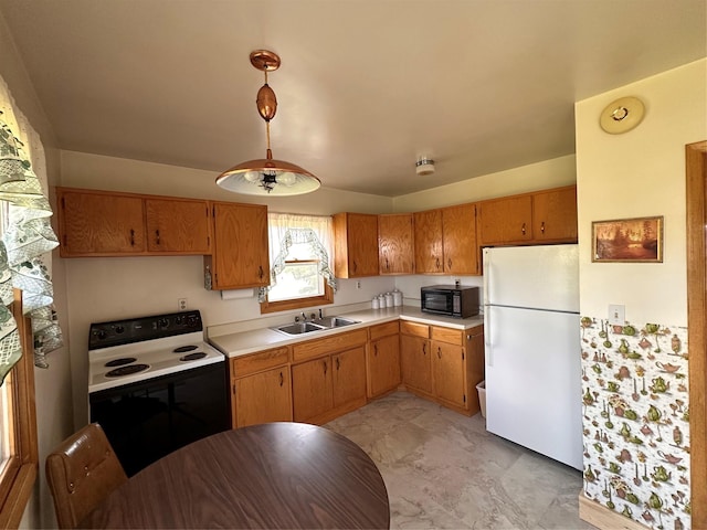 kitchen with black microwave, range with electric stovetop, a sink, light countertops, and freestanding refrigerator