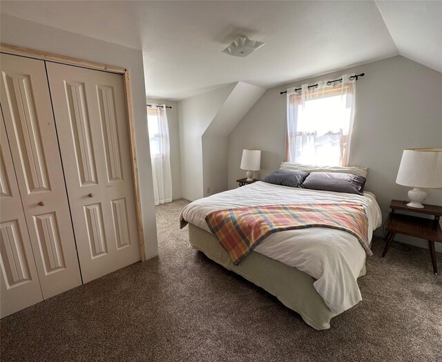 carpeted bedroom featuring vaulted ceiling and a closet