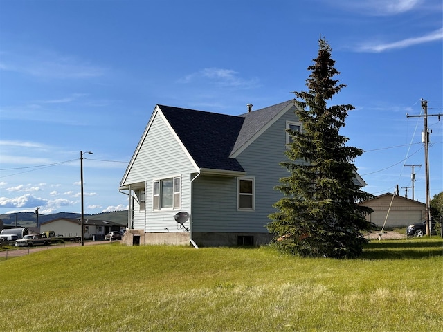 view of home's exterior featuring a shingled roof and a yard