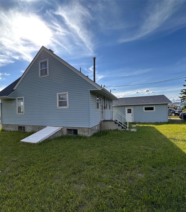 rear view of house featuring a lawn