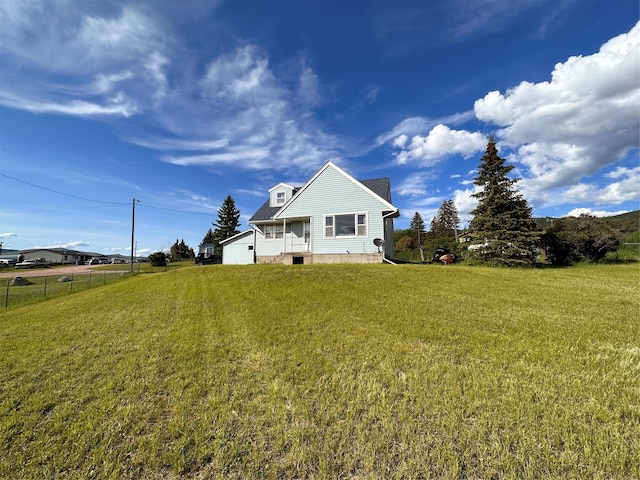 back of house featuring a yard and fence