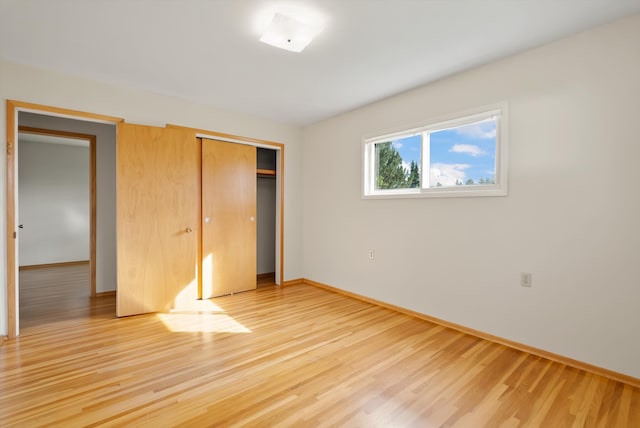 unfurnished bedroom featuring wood-type flooring and a closet