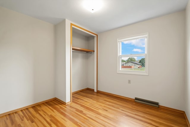 unfurnished bedroom with light hardwood / wood-style floors and a closet