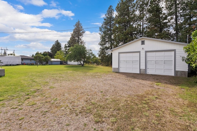 view of yard featuring a garage and an outbuilding