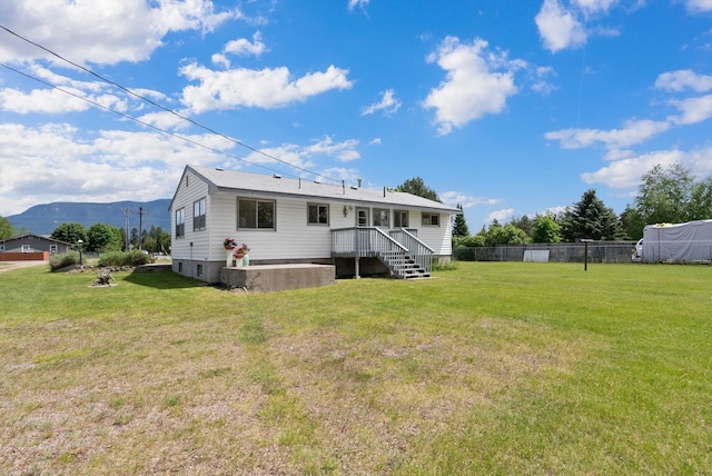 rear view of property with a mountain view and a yard