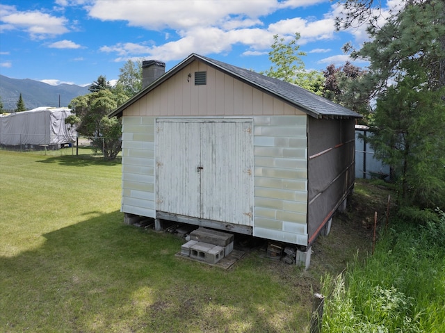 view of outdoor structure featuring a mountain view and a lawn