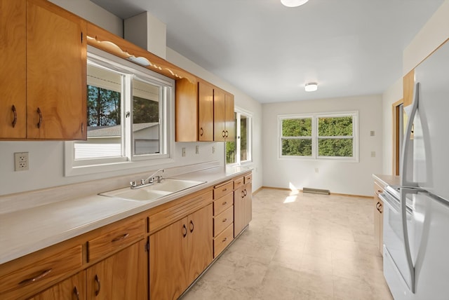 kitchen featuring white fridge, range, and sink