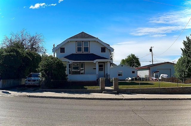 view of front facade with a front yard, a garage, and an outbuilding