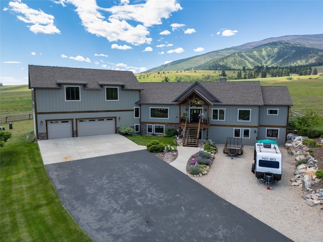 view of front of property featuring a mountain view, a garage, and a front yard