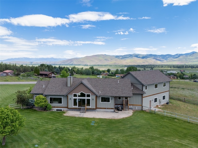 view of front of home featuring a garage, a mountain view, and a front yard