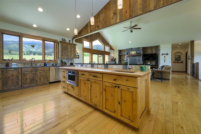 kitchen featuring light hardwood / wood-style floors, sink, a wealth of natural light, and high vaulted ceiling