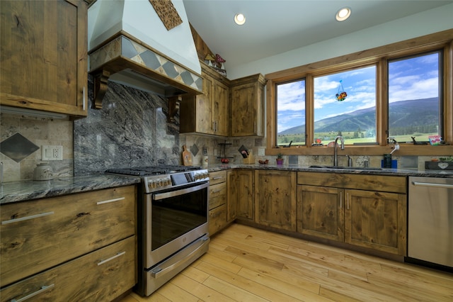 kitchen featuring plenty of natural light, appliances with stainless steel finishes, tasteful backsplash, and custom range hood